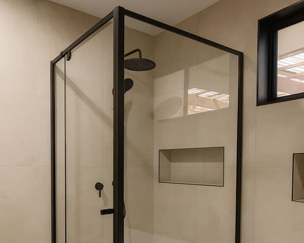 Semi-framed shower screen with black frame and fixtures